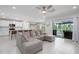 Open floorplan with a comfortable sectional couch and patio doors leading to a screened-in patio with a grill at 9148 Royal River Cir, Parrish, FL 34219