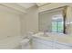 Clean bathroom with vanity, toilet, and a view to the outside through the mirror at 933 Sunridge Way # B5, Sarasota, FL 34234