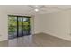 Light-filled bedroom featuring wood-look floors and sliding glass doors to the balcony at 933 Sunridge Way # B5, Sarasota, FL 34234