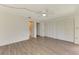 Spacious bedroom with wood-look floors, ceiling fan, and closet, leading into bathroom at 933 Sunridge Way # B5, Sarasota, FL 34234