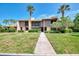 Inviting condo with a lush green lawn and mature palm trees against a bright blue sky at 933 Sunridge Way # B5, Sarasota, FL 34234