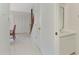 Bright hallway leading to a half bath and stairs, complemented by tile flooring and white walls at 933 Sunridge Way # B5, Sarasota, FL 34234