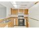 Kitchen featuring wood-style cabinets, essential appliances and ample counter space at 933 Sunridge Way # B5, Sarasota, FL 34234