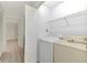 Bright laundry room featuring a washer, dryer, and shelving for optimal organization at 933 Sunridge Way # B5, Sarasota, FL 34234