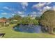 Scenic pond with a fountain, surrounded by lush greenery and trees, as seen from above at 933 Sunridge Way # B5, Sarasota, FL 34234
