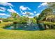 A picturesque pond with a fountain surrounded by lush landscaping offers a serene view at 933 Sunridge Way # B5, Sarasota, FL 34234