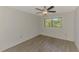 Bedroom featuring wood-look floors and a view of lush trees at 935 Sunridge Way # B4, Sarasota, FL 34234