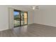 Spacious bedroom with laminated floors and sliding glass doors to a balcony and a ceiling fan at 935 Sunridge Way # B4, Sarasota, FL 34234