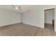 Bright bedroom with wood-look floors, ceiling fan, and white walls at 935 Sunridge Way # B4, Sarasota, FL 34234