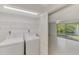 Convenient laundry room featuring a washer, dryer, storage shelves, and views of the water fountain at 935 Sunridge Way # B4, Sarasota, FL 34234