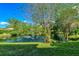 Beautiful pond with fountain feature, surrounded by lush greenery and mature trees at 935 Sunridge Way # B4, Sarasota, FL 34234