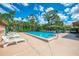 Relaxing pool area with lounge chairs, clear blue water, and lush tropical landscaping at 935 Sunridge Way # B4, Sarasota, FL 34234