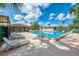 Sparkling swimming pool featuring lounge chairs, surrounding greenery, and serene sunny views at 935 Sunridge Way # B4, Sarasota, FL 34234