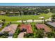 An aerial view shows the property with a red tile roof near a golf course, a lake, and other homes at 9719 Discovery Ter, Bradenton, FL 34212