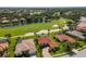 Beautiful aerial view of houses nestled around a verdant golf course with a sand trap and pond at 9719 Discovery Ter, Bradenton, FL 34212