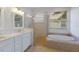 Bright bathroom featuring a double vanity, glass shower, and soaking tub at 9719 Discovery Ter, Bradenton, FL 34212