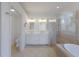 Bright bathroom featuring a double vanity, glass shower, and soaking tub at 9719 Discovery Ter, Bradenton, FL 34212