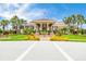 Community clubhouse featuring manicured landscaping, a grand entrance, and ample parking at 9719 Discovery Ter, Bradenton, FL 34212