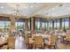 Elegant dining room with large windows, beautiful chandeliers, and a lovely view of the surrounding landscape at 9719 Discovery Ter, Bradenton, FL 34212