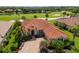 Aerial view showcases a brick driveway and lush landscaping with palm trees on a beautiful home at 9719 Discovery Ter, Bradenton, FL 34212