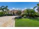 Stunning home featuring a brick driveway and lush landscaping with palm trees and flowering bushes at 9719 Discovery Ter, Bradenton, FL 34212