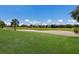 Sprawling golf course features vibrant green grass and a sandy bunker in front of tree line with sky above at 9719 Discovery Ter, Bradenton, FL 34212