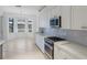 Bright kitchen features white cabinets, stainless steel appliances, marble countertops, and tiled backsplash at 9719 Discovery Ter, Bradenton, FL 34212