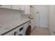Laundry room features modern washer and dryer, marble countertops, sink and white cabinets at 9719 Discovery Ter, Bradenton, FL 34212