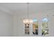 Bright Living room with neutral paint, a decorative chandelier, and arched windows with views of the front yard at 9719 Discovery Ter, Bradenton, FL 34212