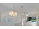 Open-concept living room with a chandelier and sliding glass doors to the pool area at 9719 Discovery Ter, Bradenton, FL 34212