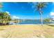 Scenic lake view from expansive backyard with lush landscaping and clear blue skies at 10055 Franklin Dr, Englewood, FL 34224