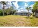 Expansive backyard featuring lush lawn and tranquil views of the screened-in pool at 10055 Franklin Dr, Englewood, FL 34224