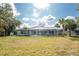 Backyard view showcasing the property with a screened-in pool and mature trees at 10055 Franklin Dr, Englewood, FL 34224
