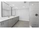 Modern bathroom featuring double sinks, a quartz countertop, and a separate tiled shower at 10055 Franklin Dr, Englewood, FL 34224