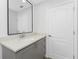 This bathroom features a modern grey vanity with a white countertop and black framed mirror at 10055 Franklin Dr, Englewood, FL 34224