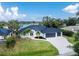 Beautiful view of a home next to the water with a well-manicured lawn and three car garage at 10055 Franklin Dr, Englewood, FL 34224