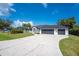 Well-maintained home featuring a three-car garage and manicured front lawn with a circular driveway at 10055 Franklin Dr, Englewood, FL 34224
