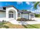 Well-manicured home featuring arched windows and a three-car garage at 10055 Franklin Dr, Englewood, FL 34224