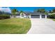 Well-maintained one-story home featuring a three-car garage and lush green lawn at 10055 Franklin Dr, Englewood, FL 34224