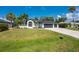 Beautifully landscaped two-story home featuring palm trees and a well-manicured lawn at 10055 Franklin Dr, Englewood, FL 34224
