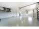 Large, bright three-car garage with sealed floors, ample lighting, and access doors at 10055 Franklin Dr, Englewood, FL 34224