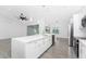 Bright kitchen featuring a large island with quartz countertops, stainless steel appliances, and modern pendant lighting at 10055 Franklin Dr, Englewood, FL 34224
