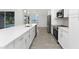Modern kitchen with stainless steel appliances, white cabinets, and a large island with quartz countertops overlooking the pool at 10055 Franklin Dr, Englewood, FL 34224