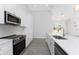 Bright kitchen showcasing quartz countertops, stainless steel appliances, and a breakfast bar area with modern pendant lighting at 10055 Franklin Dr, Englewood, FL 34224