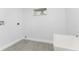 A laundry room featuring tile floors, utility sink, and a small window at 10055 Franklin Dr, Englewood, FL 34224