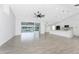 Bright living room with tile flooring, a sliding glass door to a screened pool, and modern kitchen at 10055 Franklin Dr, Englewood, FL 34224