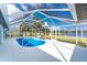 Enclosed pool area featuring an ample deck and serene backyard vistas at 10055 Franklin Dr, Englewood, FL 34224