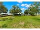 Large backyard with green grass, shade trees, and a shed, ideal for recreation and storage at 1035 Axlewood Cir, Brandon, FL 33511