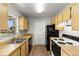 Efficient kitchen featuring wood cabinets, black appliances, and stainless-steel sink at 1035 Axlewood Cir, Brandon, FL 33511