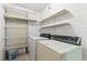 Functional laundry room with washer, dryer, storage shelves and cinder block walls at 1035 Axlewood Cir, Brandon, FL 33511